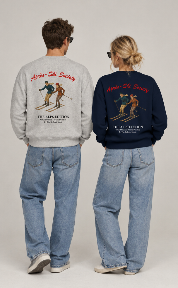 Two models shown from the back wearing matching graphic sweatshirts. The model on the left wears a light gray sweatshirt and the model on the right wears a dark navy blue sweatshirt, both featuring a vintage ski illustration and the text 'Alpine Ski Society' and 'THE ALP EDITION'.