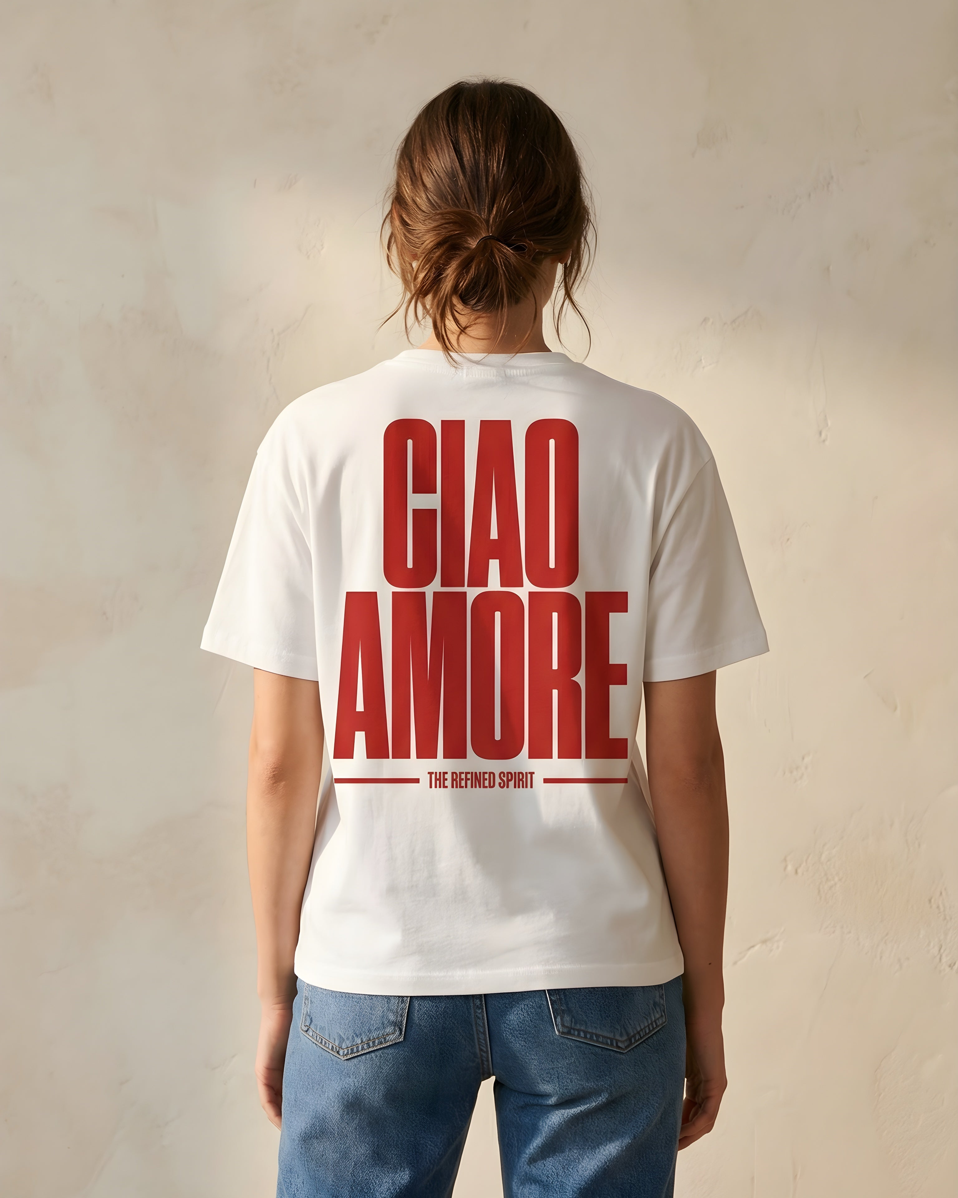 Person wearing a white t-shirt with red text 'CIAO AMORE' on the back against a plain background