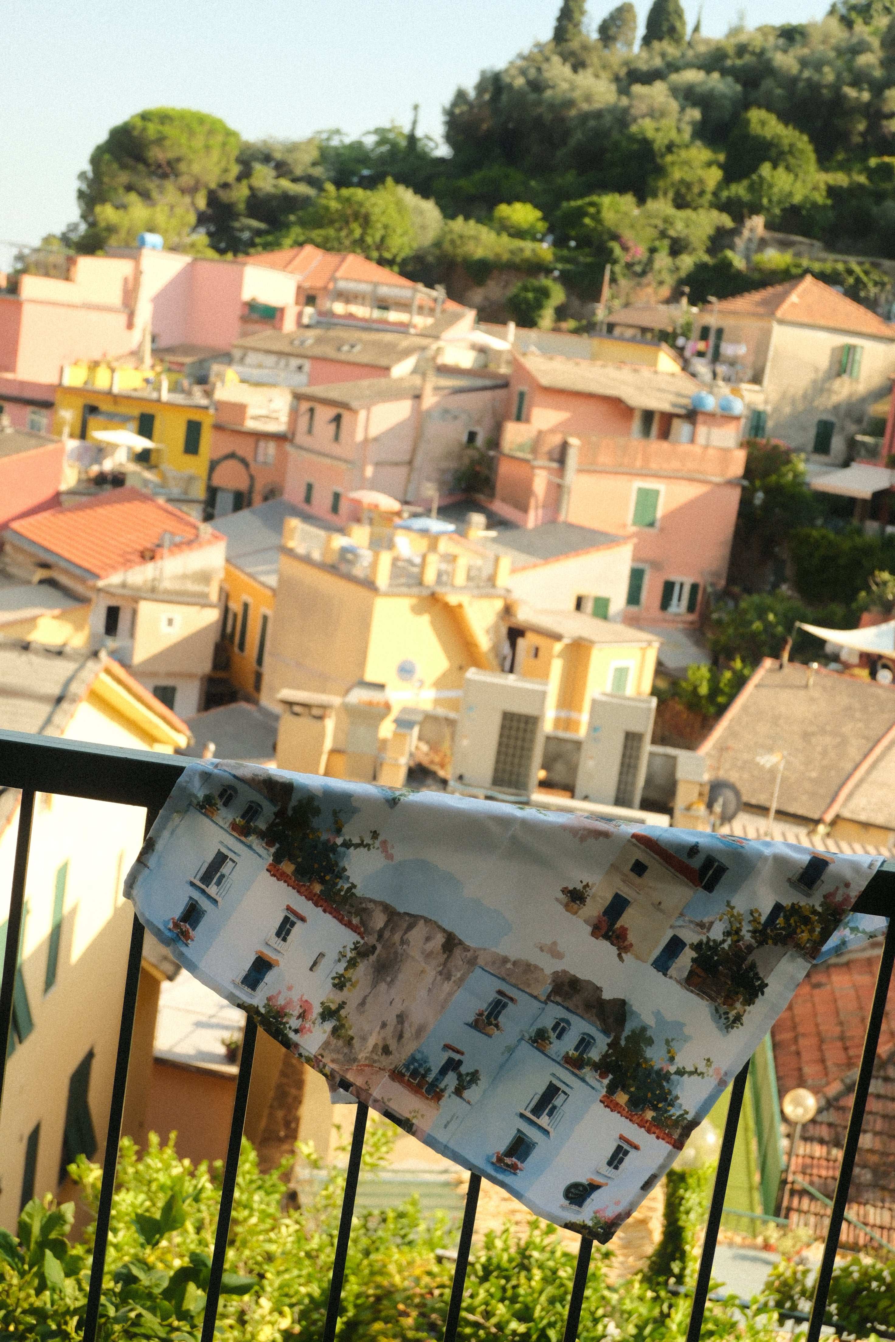 Model of a town with colorful buildings and greenery, viewed from above.