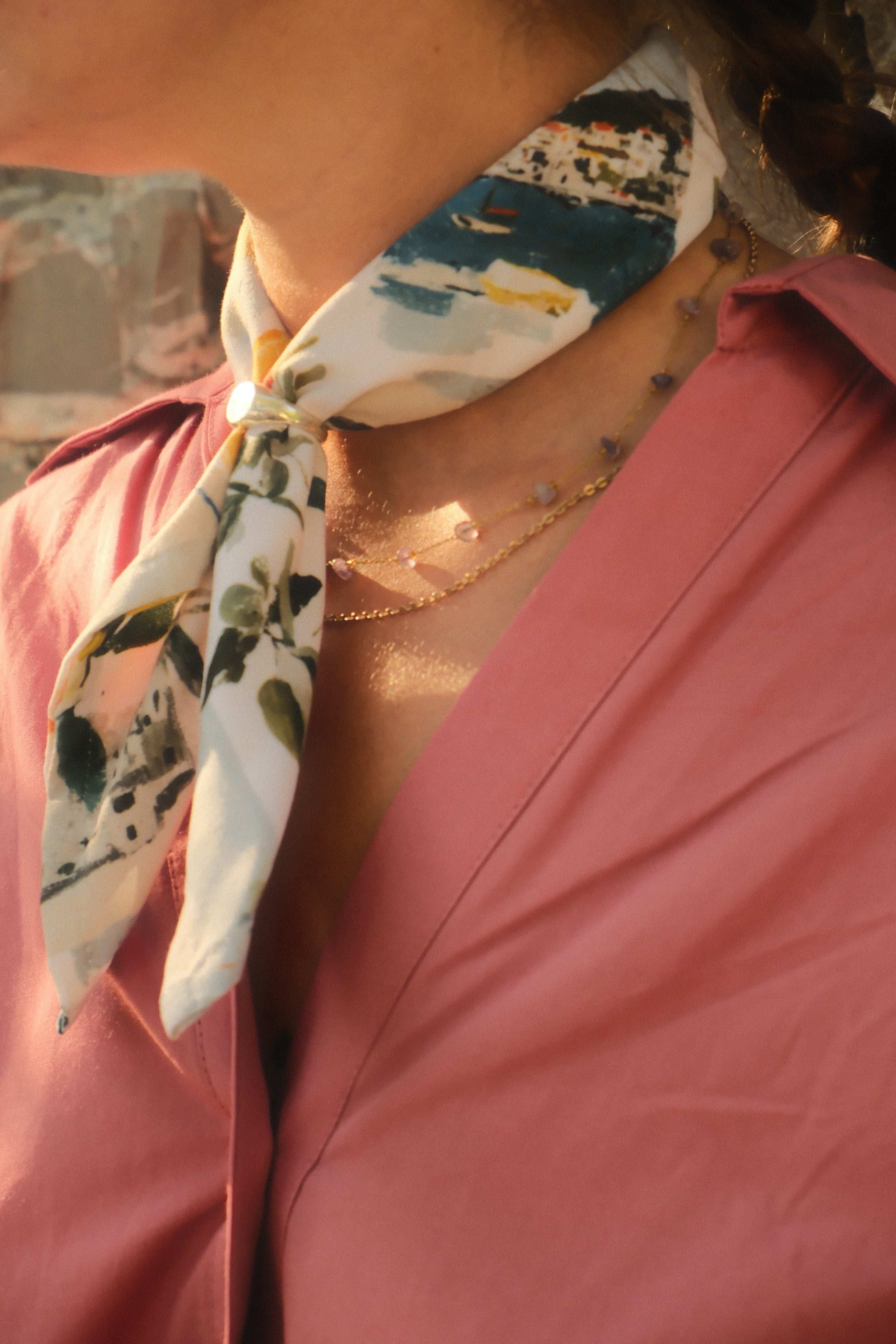 Person wearing a floral-patterned scarf with a blurred background