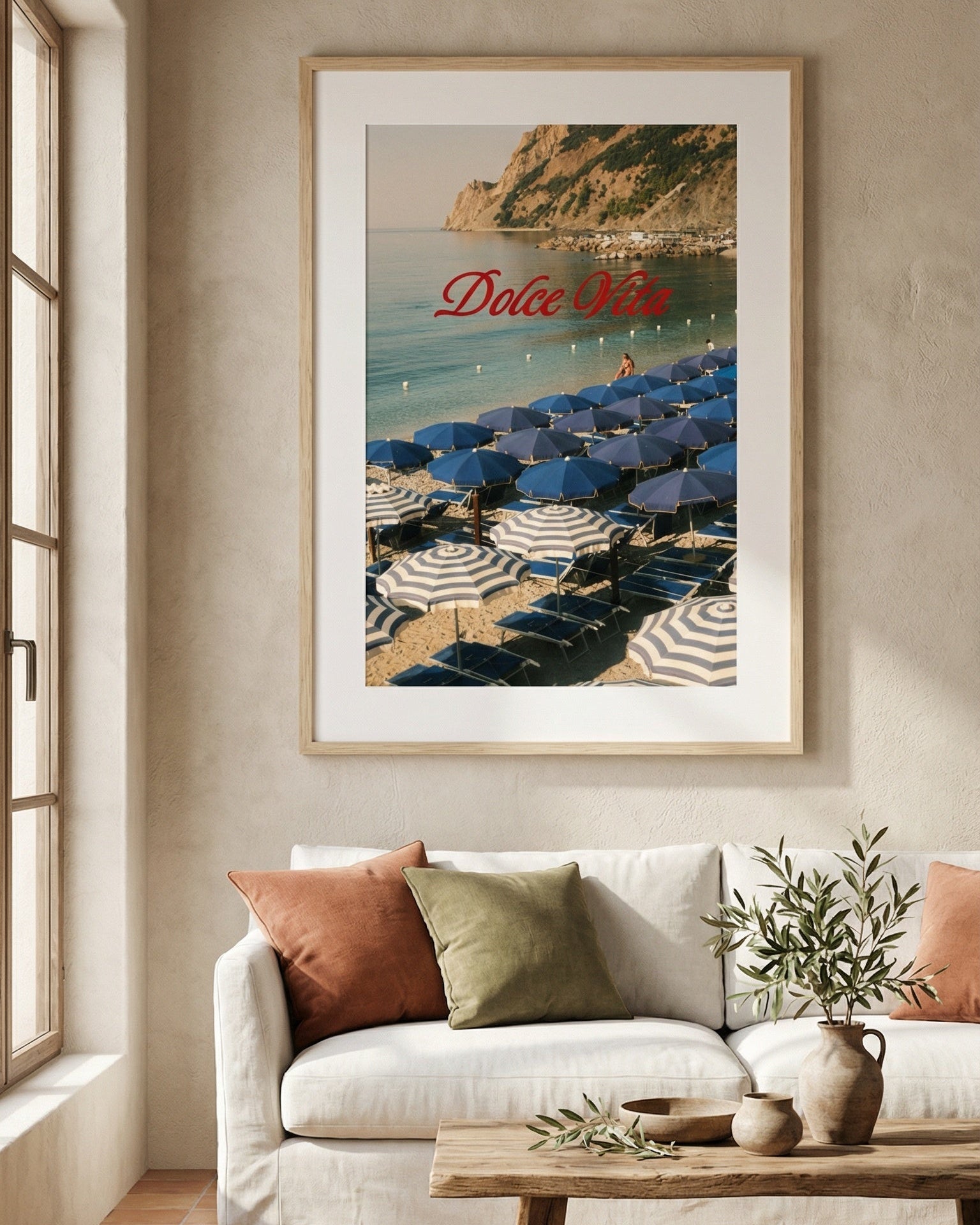 Framed artwork of a beach scene with 'Dolce Vita' text in a living room.