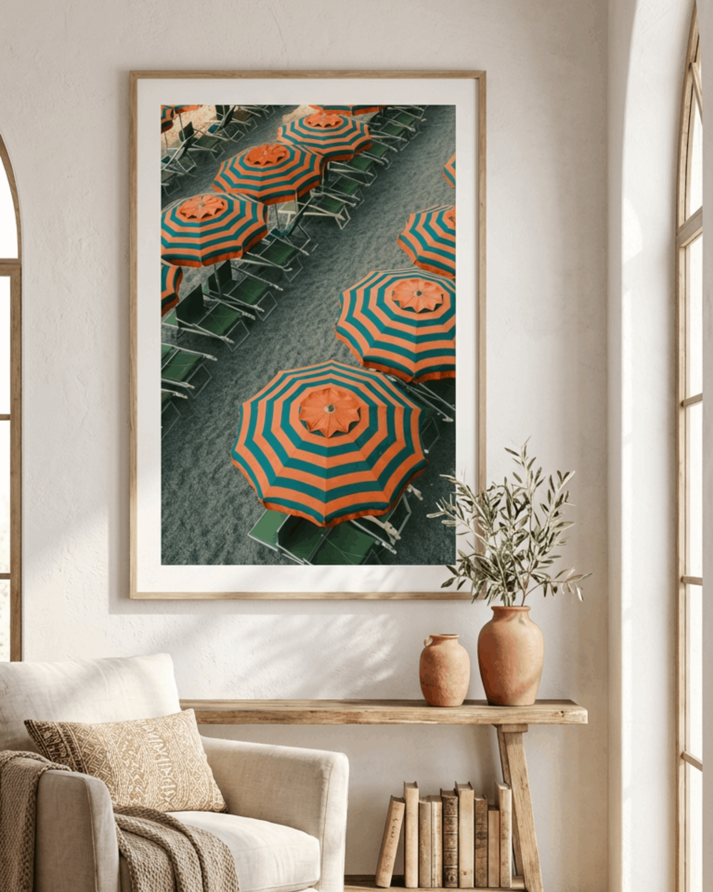 Framed artwork of orange and blue umbrellas on a green background in a living room.
