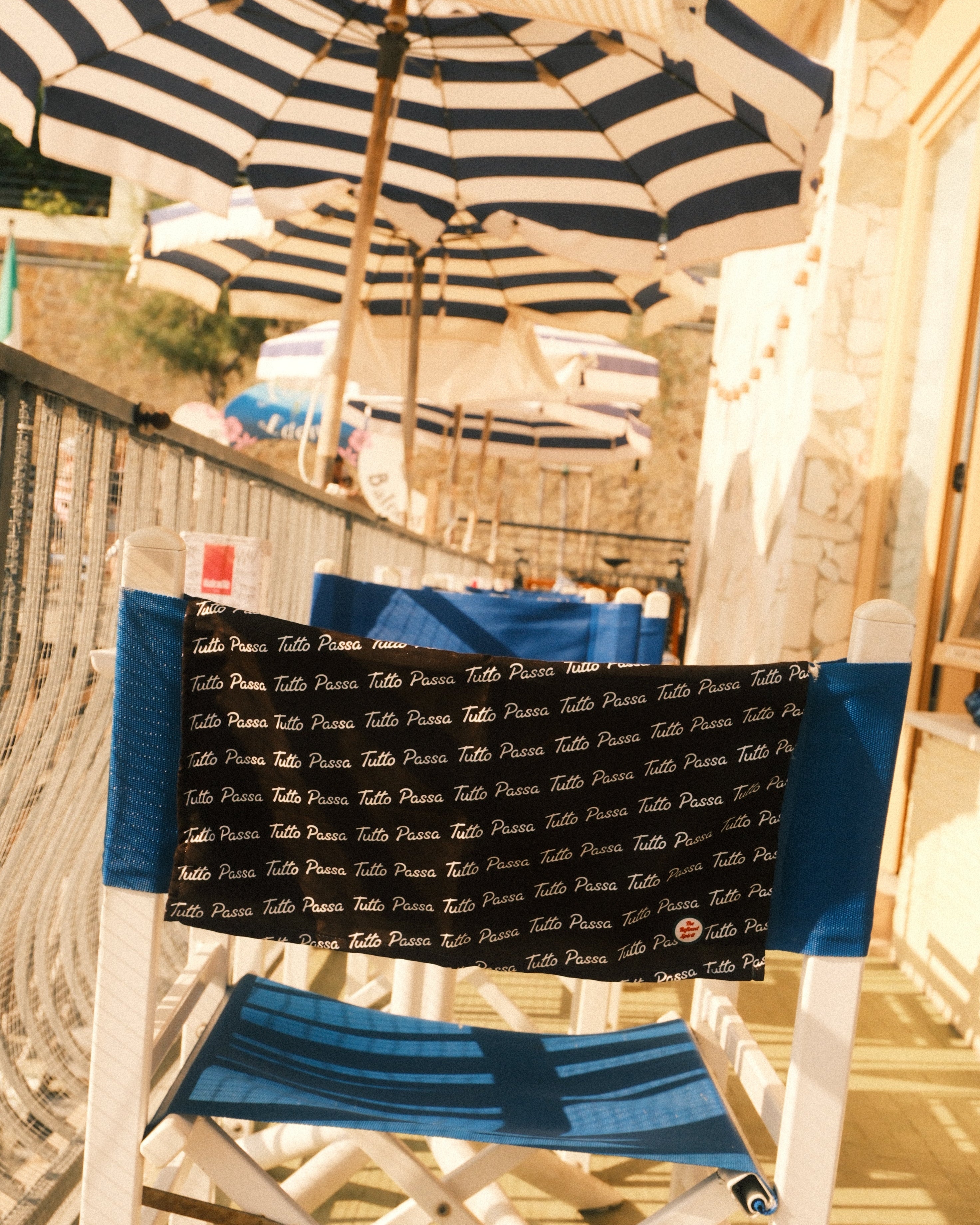 Blue and patterned scarves hanging on a drying rack outdoors.