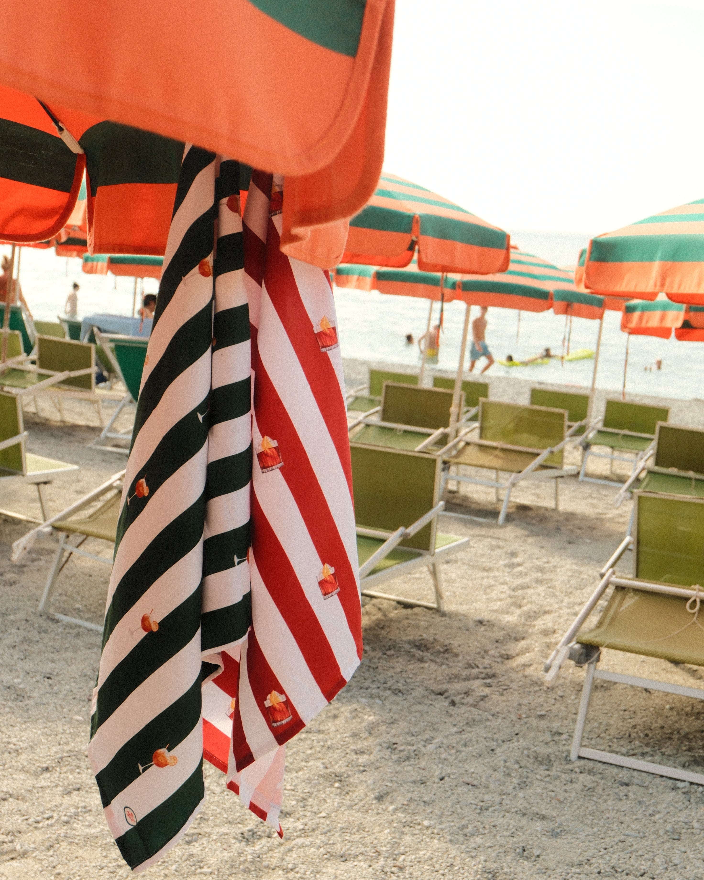 Beach umbrellas with striped patterns on a sandy beach.