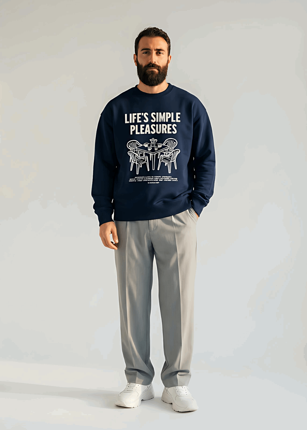 Man wearing a navy sweatshirt with 'Life's Simple Pleasures' text and gray pants on a white background