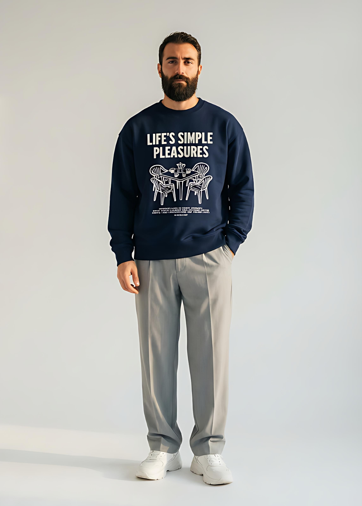 Man wearing a navy sweatshirt with 'Life's Simple Pleasures' text and gray pants on a white background
