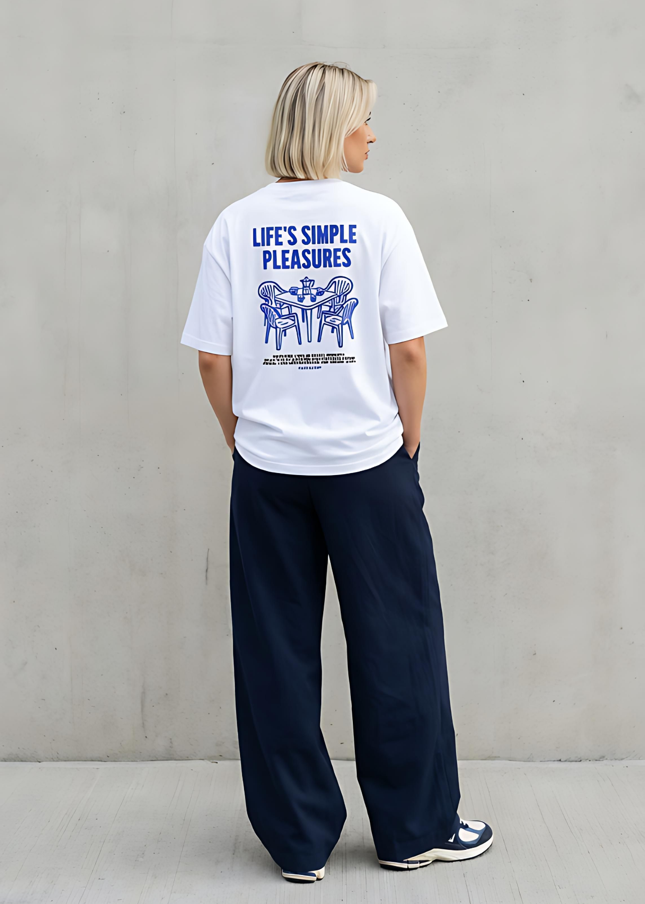 Person wearing a white t-shirt with text and graphics on the back, standing against a plain background.