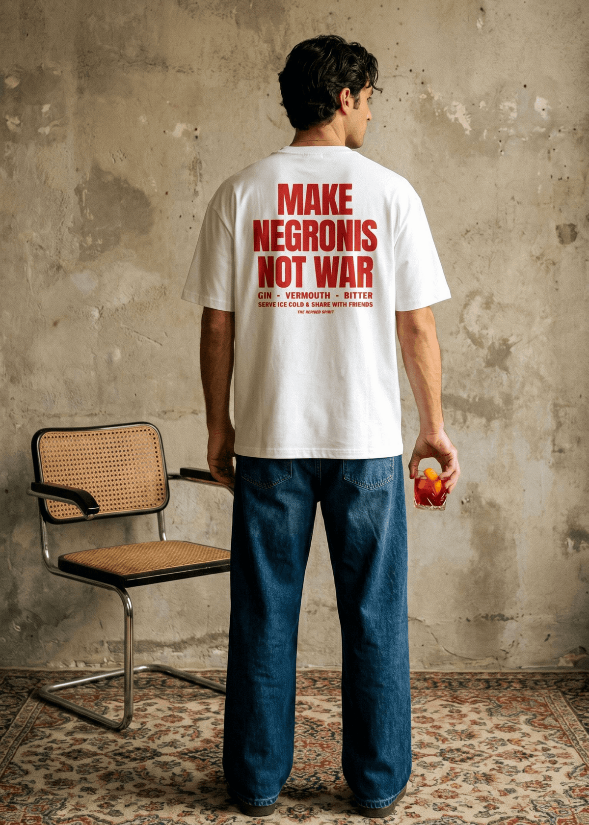 Person wearing a white t-shirt with red text, standing in a room with a chair and textured wall.