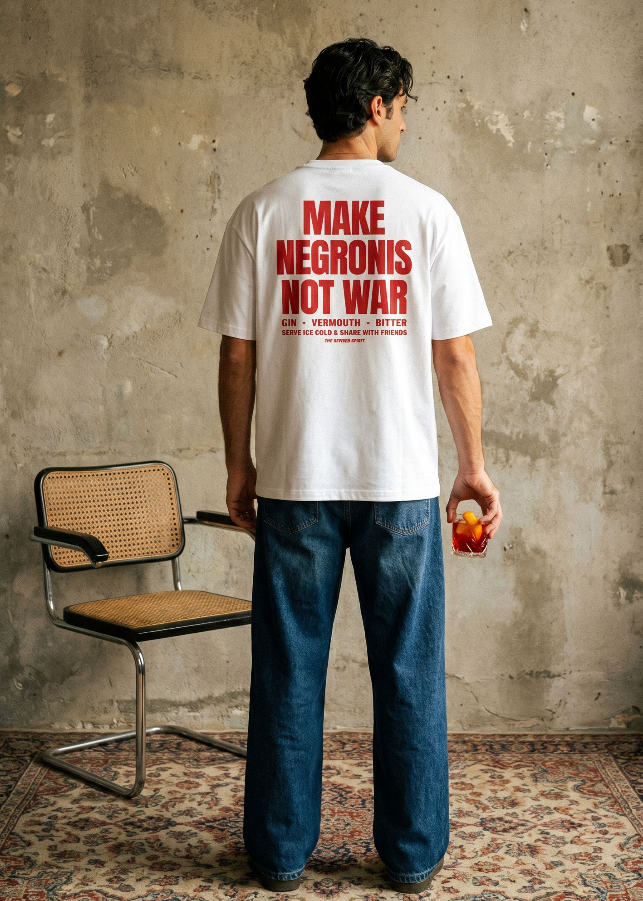 Person wearing a white t-shirt with red text, standing in a room with a chair and textured wall.