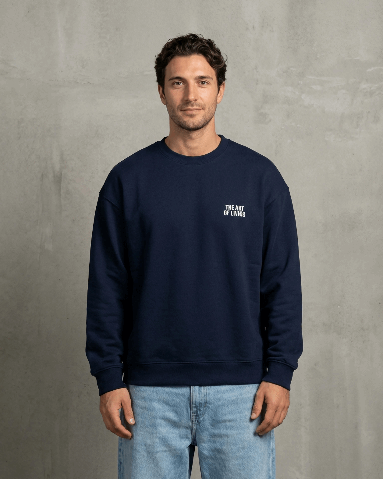 Man wearing a navy blue sweatshirt with a logo on a gray background