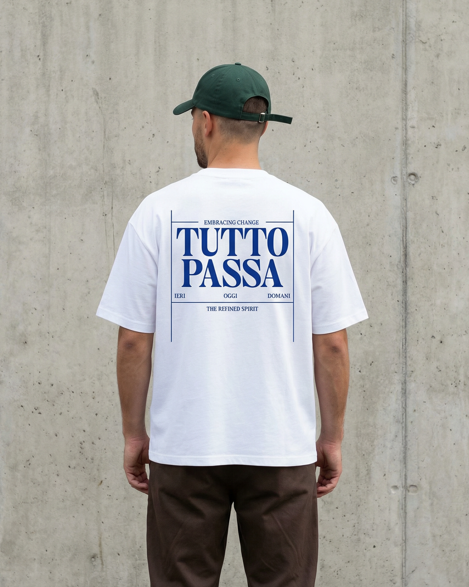 Person wearing a white t-shirt with 'TUTTO PASSA' text, standing against a concrete wall.