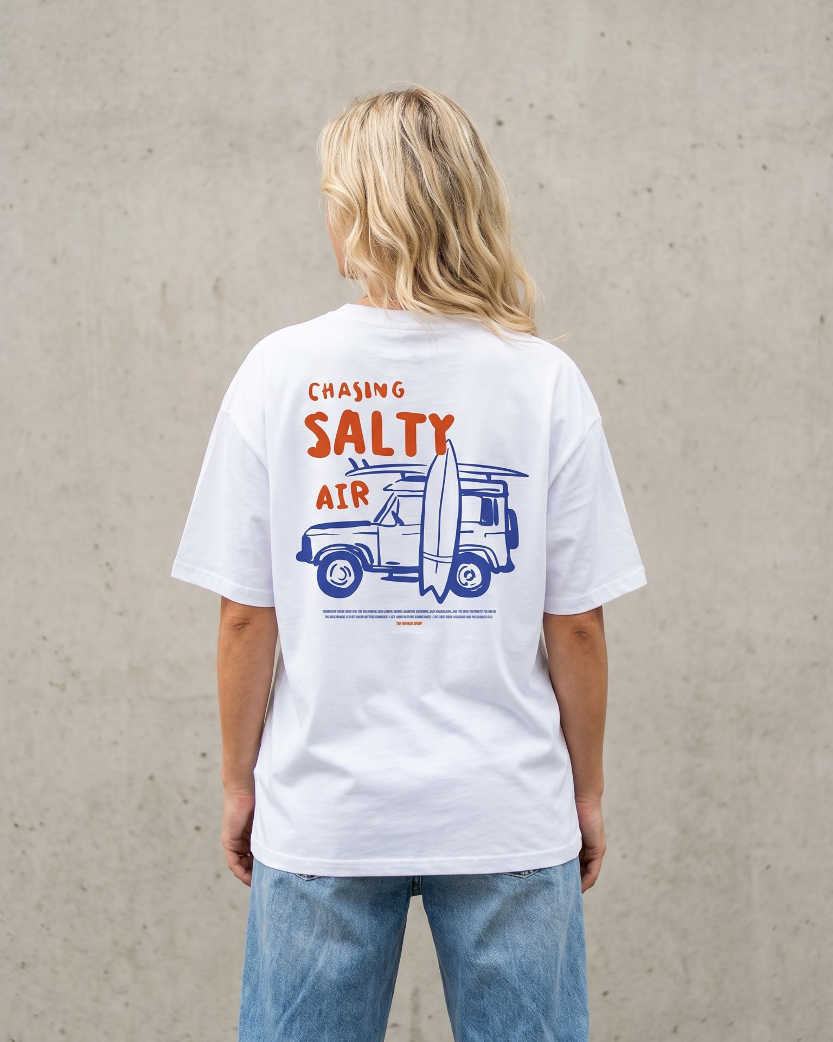 Person wearing a white t-shirt with a graphic design on the back against a plain background