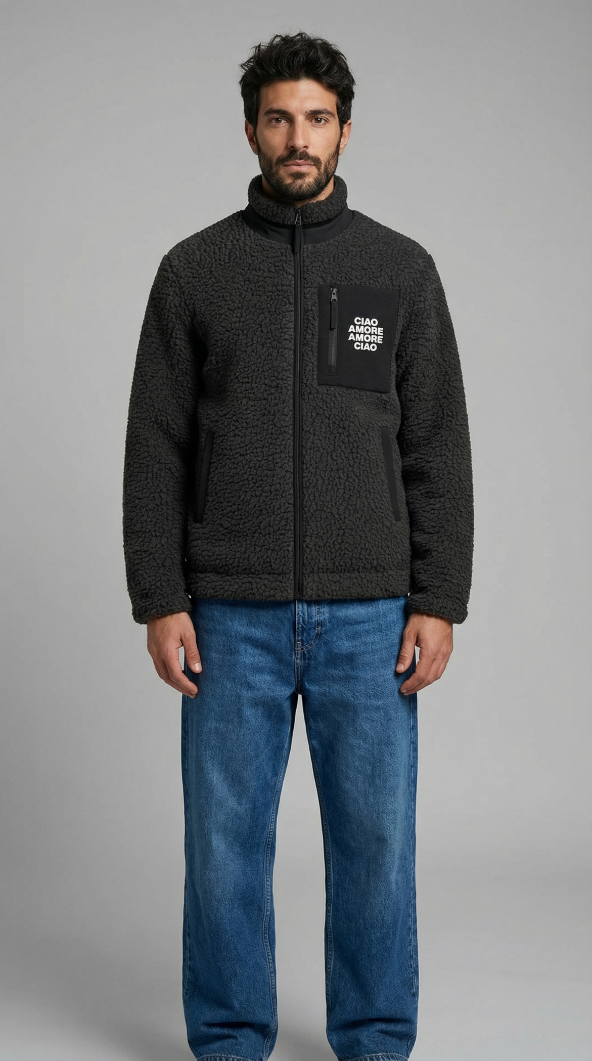 Man wearing a dark gray fleece jacket with a brand logo on a gray background