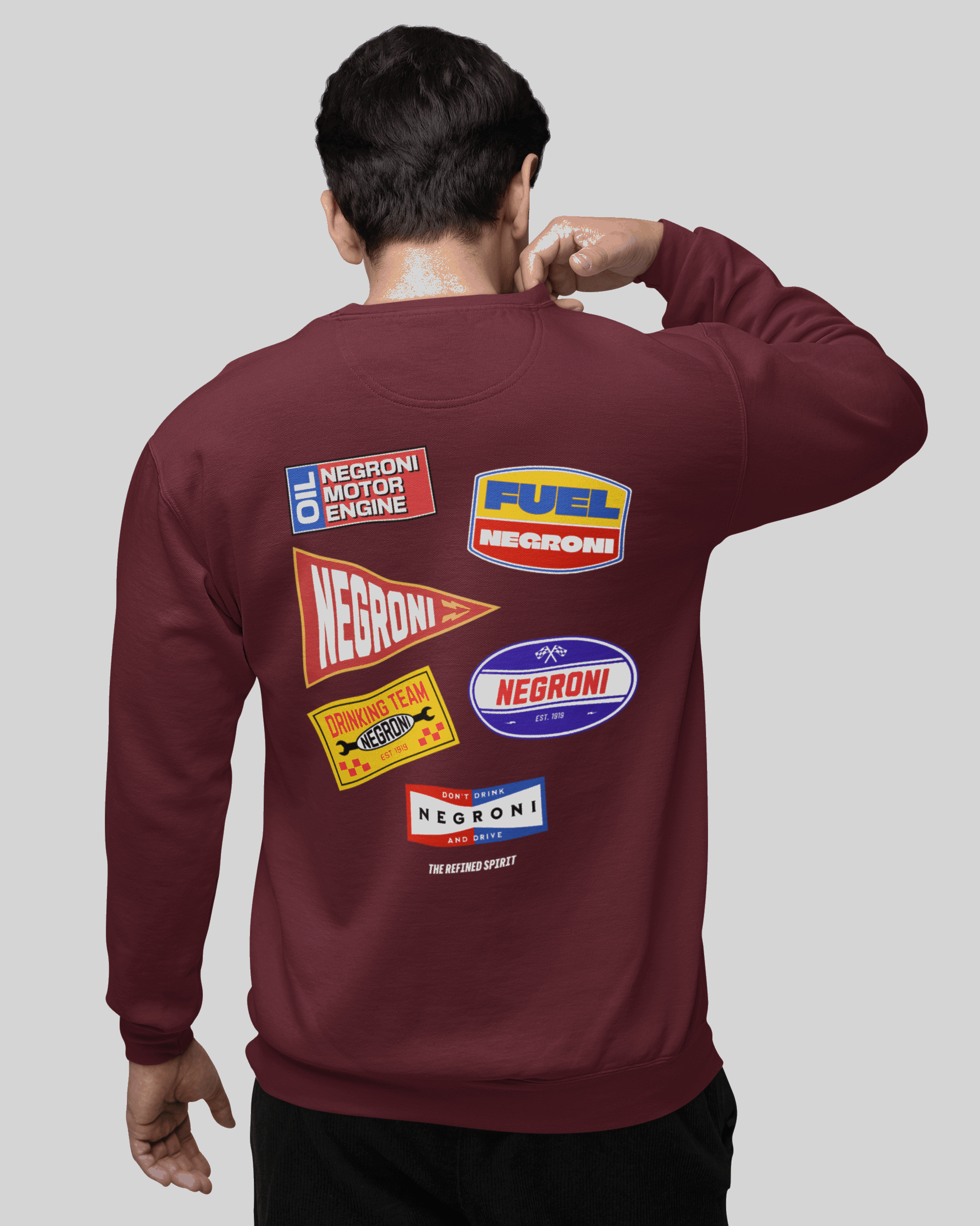 Maroon sweatshirt with colorful logos on the back worn by a person against a gray background