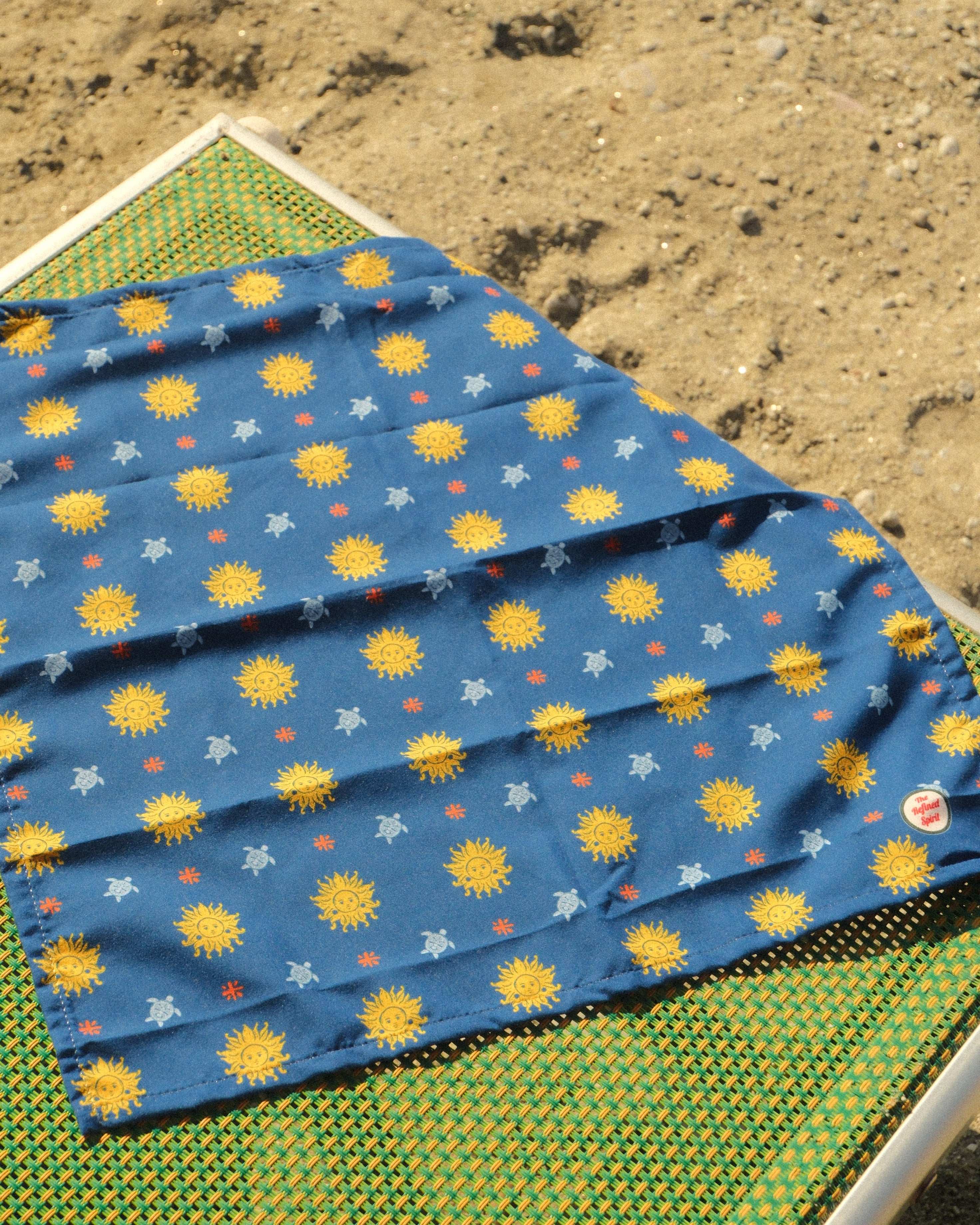 Blue fabric with sun pattern on a green and yellow checkered surface