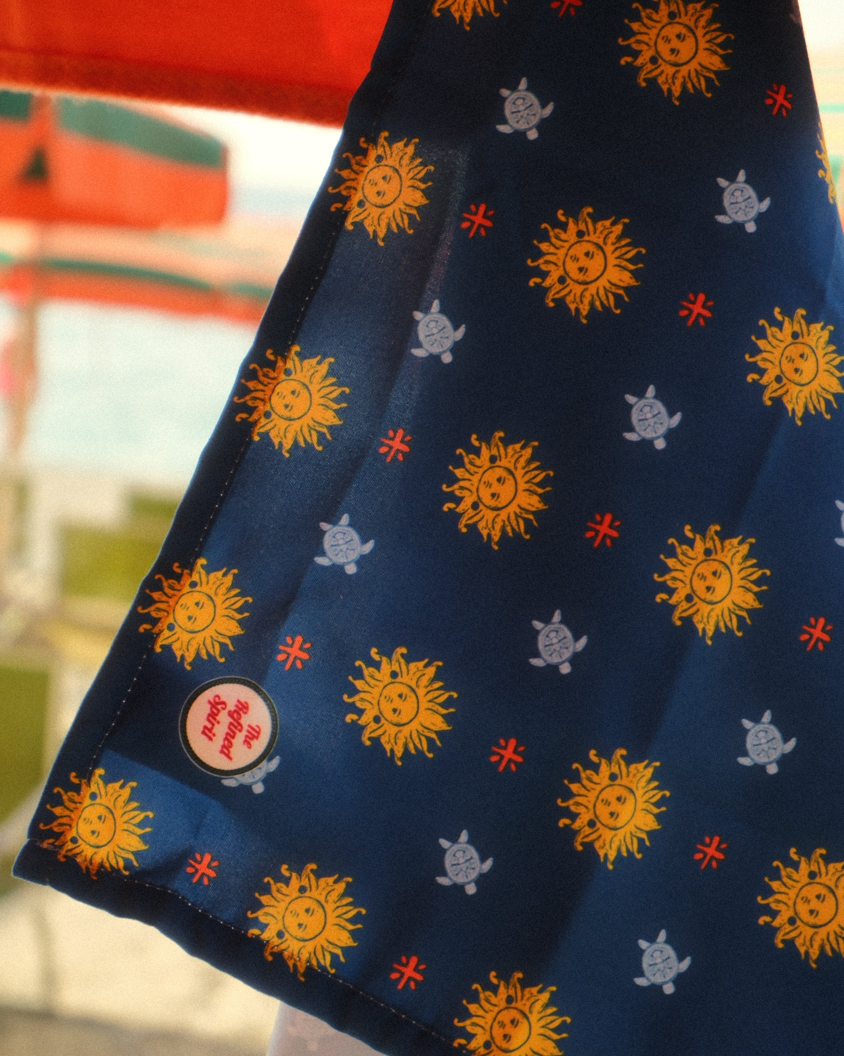 Two fabric swatches with sun patterns on a blue background