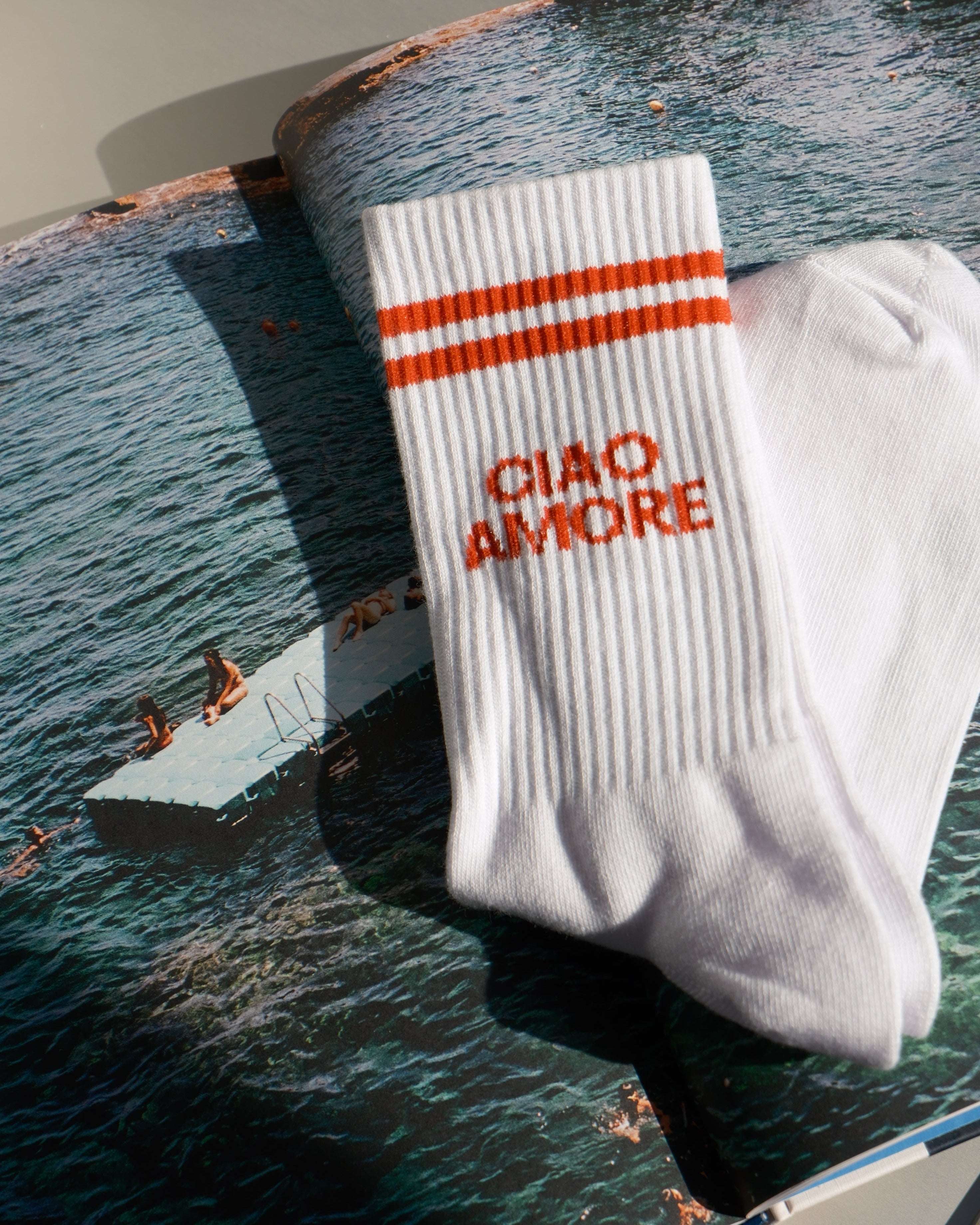 White socks with red text and stripes on a magazine with a boat image