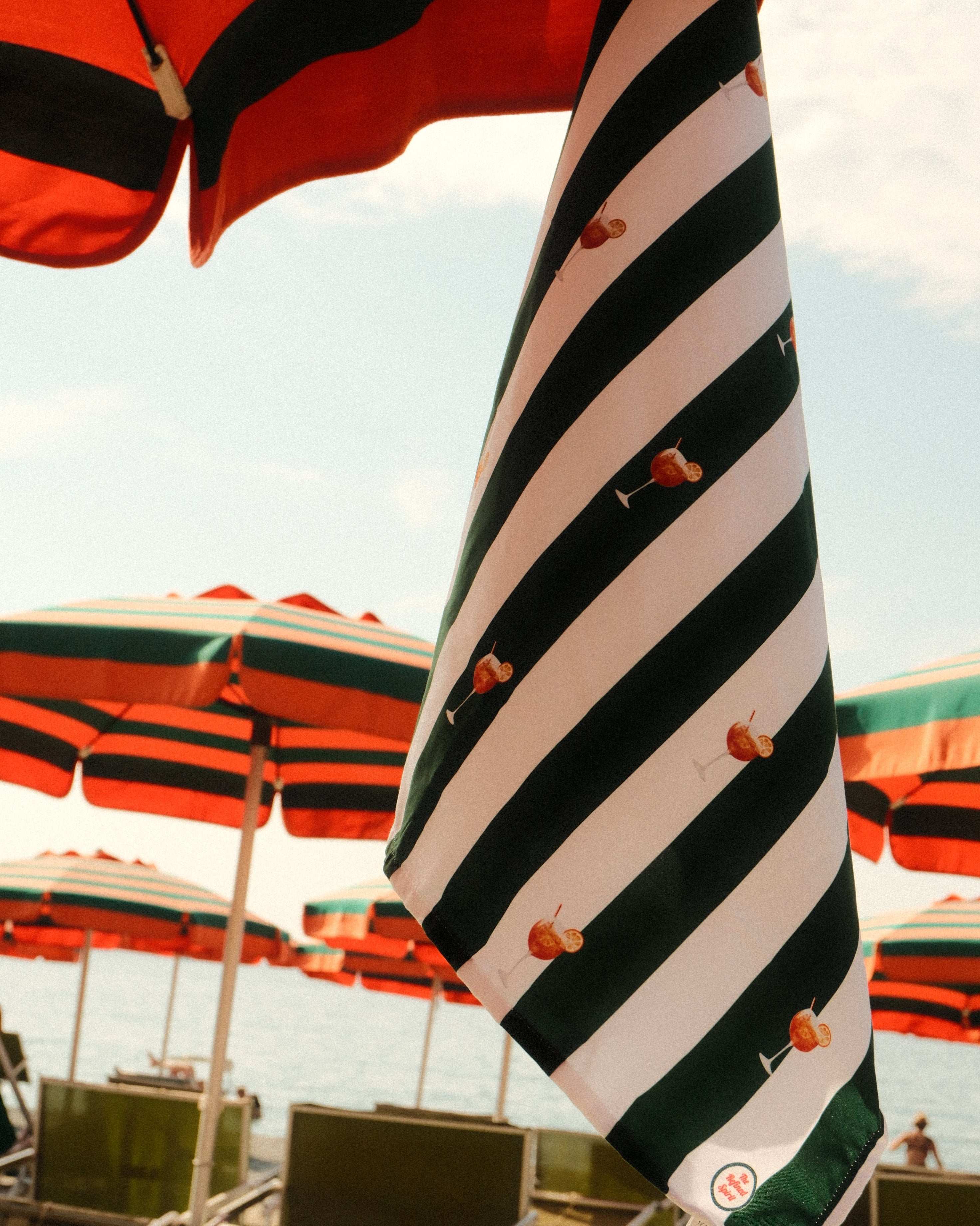Striped beach umbrellas with red and green patterns on a sunny day.