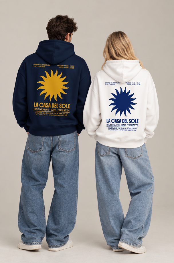 Two models from behind wearing oversized hoodies with large sun graphics and 'LA CASA DEL SOLE' text, paired with wide-leg jeans, against a neutral studio background.