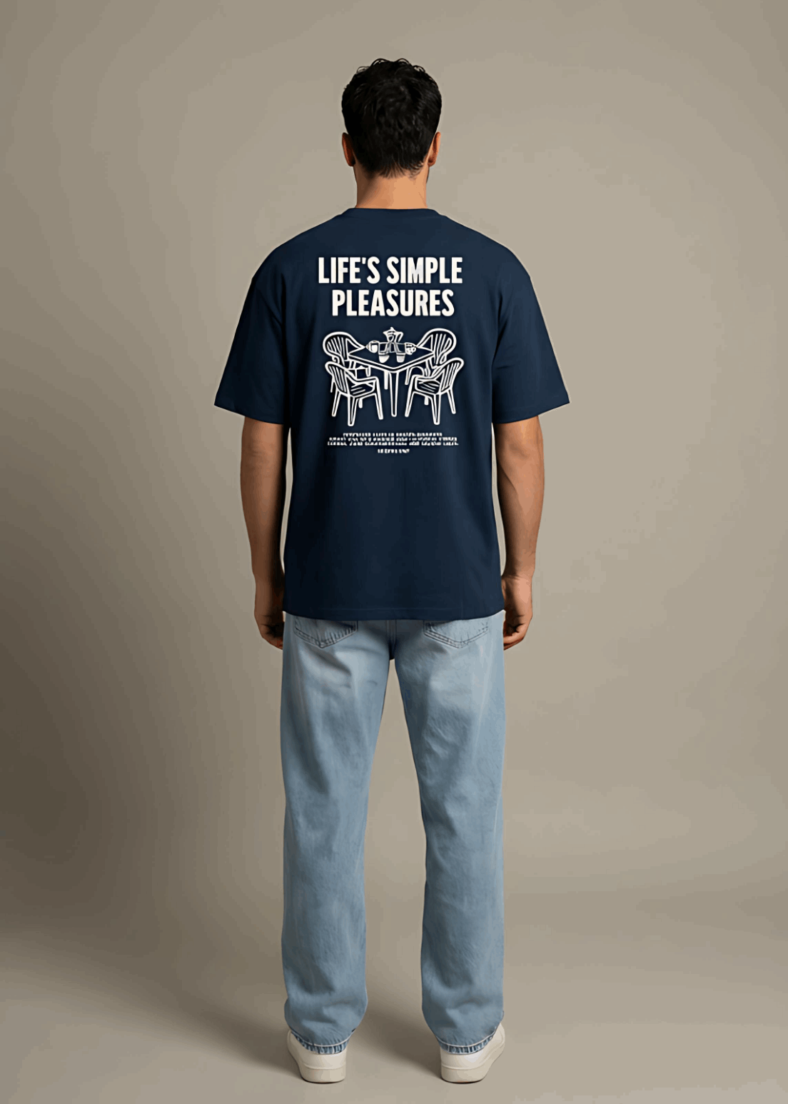 Person wearing a navy blue t-shirt with text on the back against a beige background