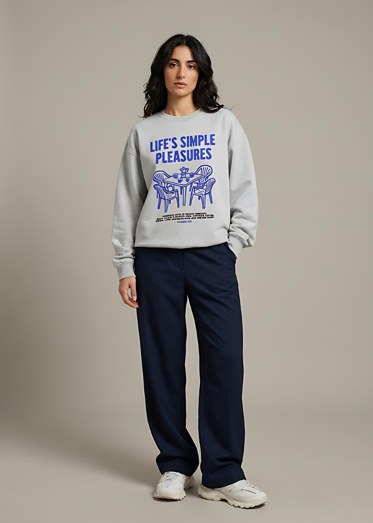 Person wearing a gray sweatshirt with text and graphics on a plain background