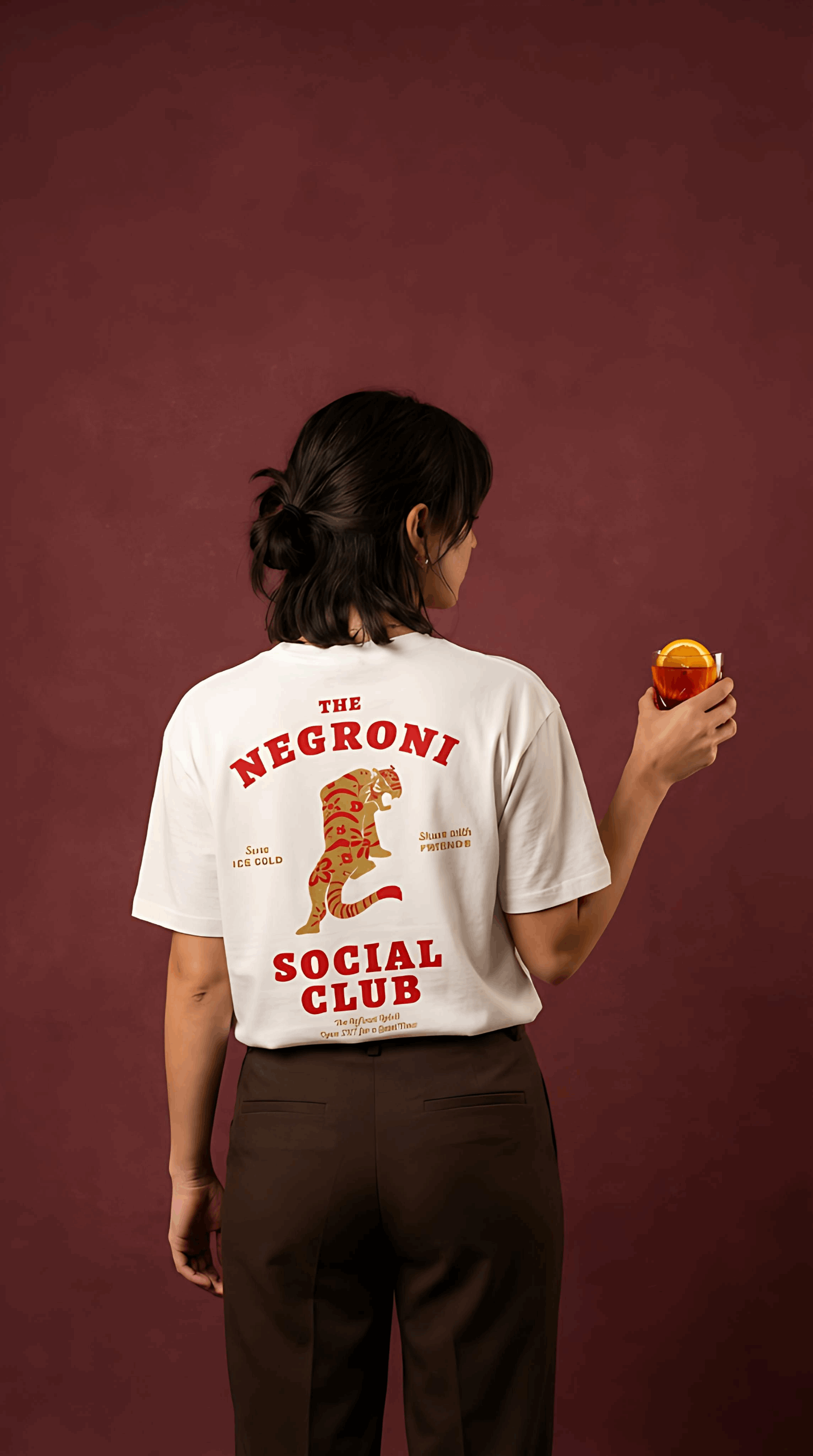 Person wearing a 'The Negroni Social Club' t-shirt against a maroon background