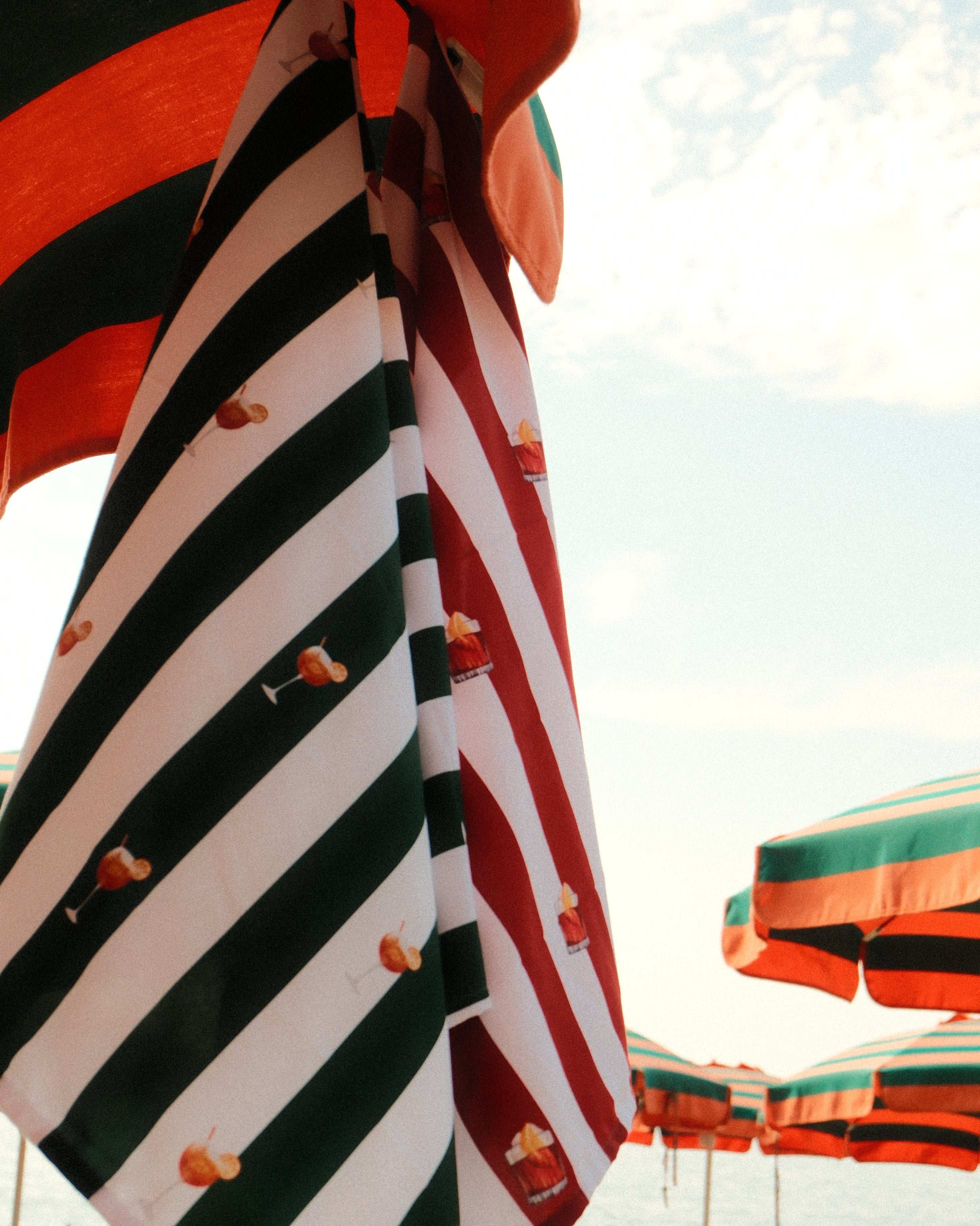 Decorative striped fabric with red, black, and green colors on a blurred background