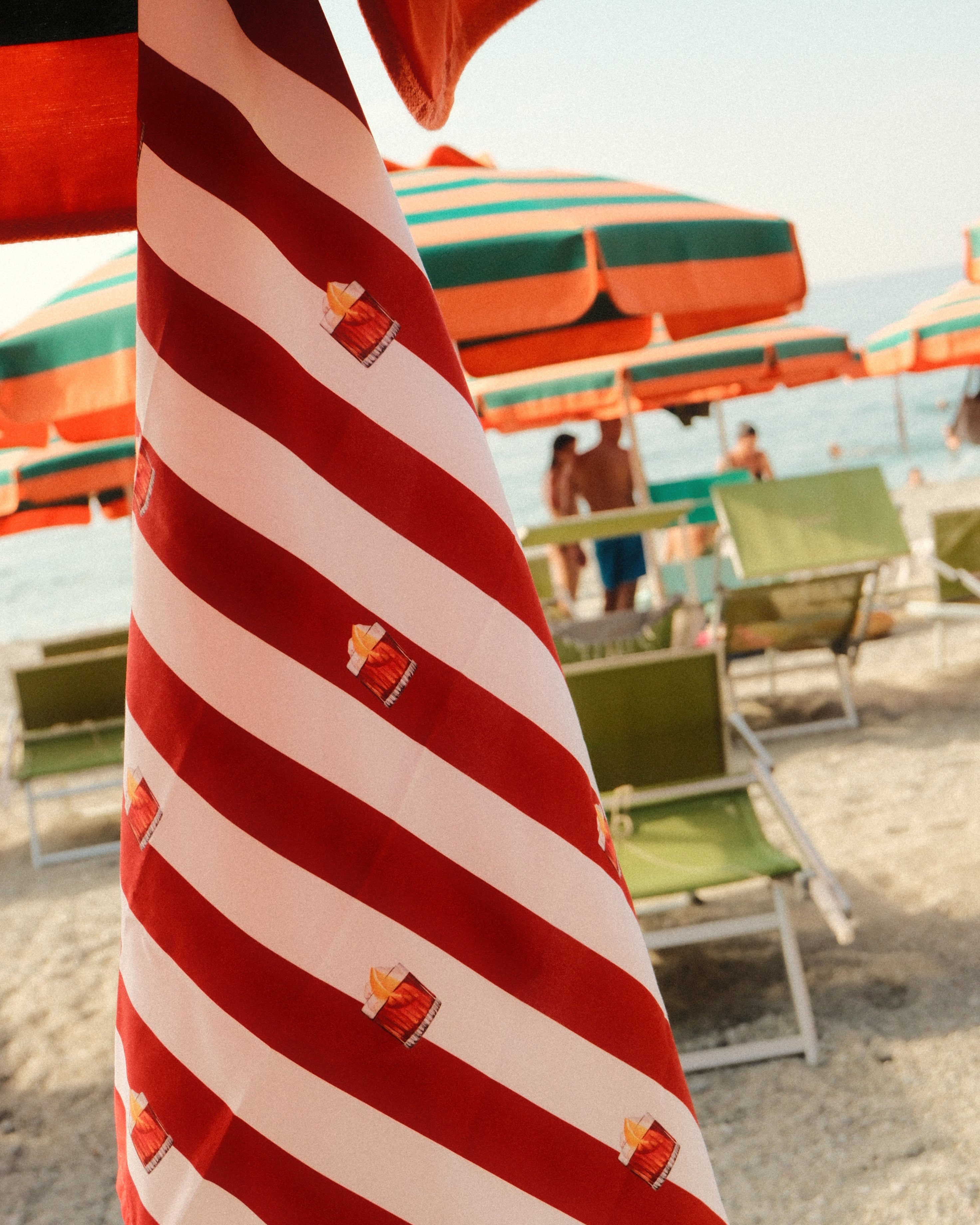 Red and white striped umbrella with decorative elements against a blurred outdoor background