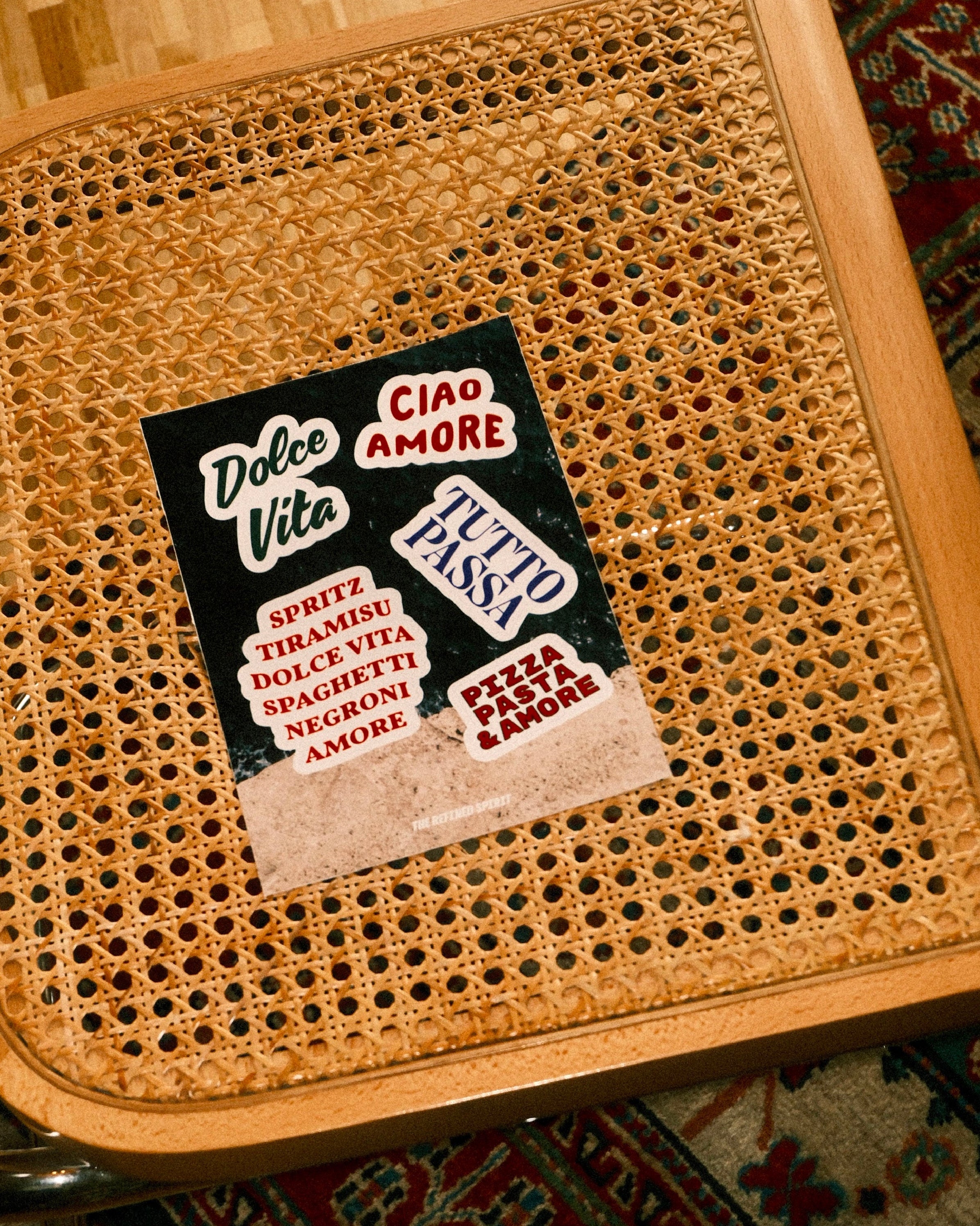 Wicker chair seat with a vintage-style advertisement poster on a patterned rug.