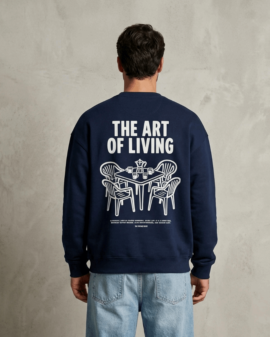 Person wearing a navy blue sweatshirt with 'The Art of Living' text and graphic on the back, standing against a plain background.