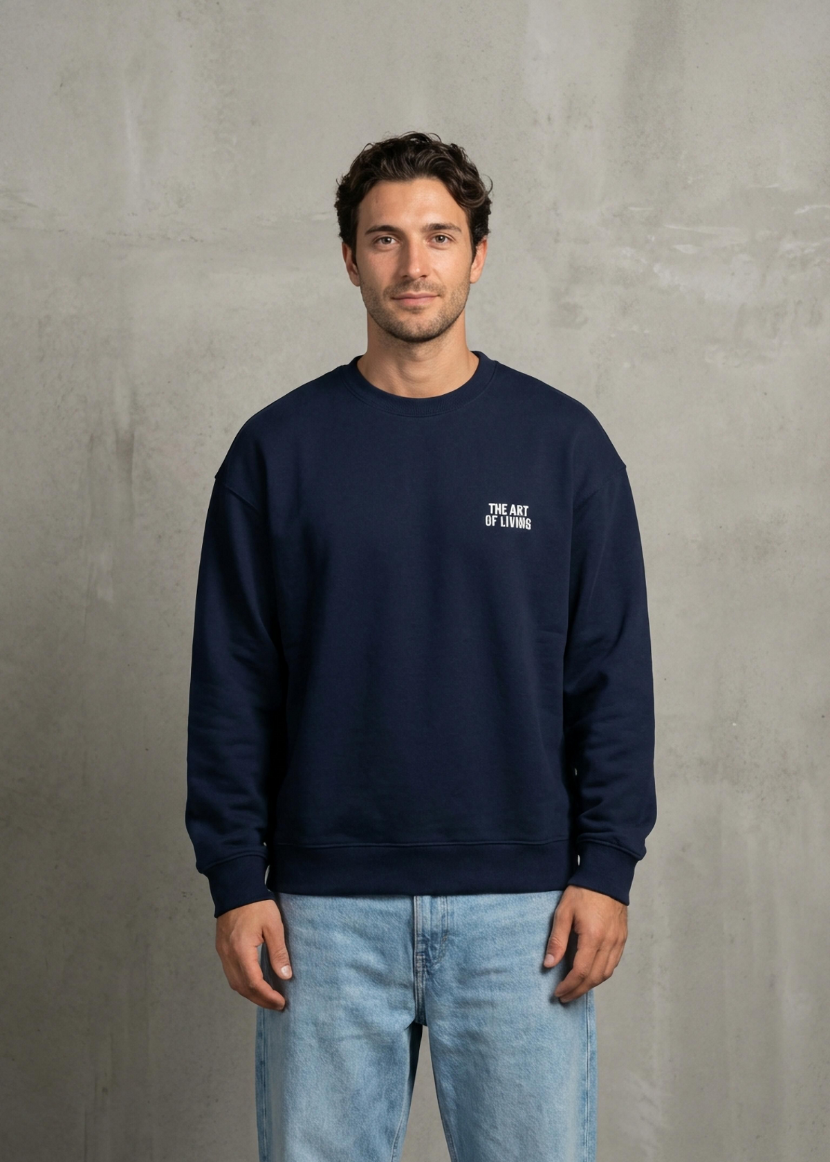 Man wearing a navy blue sweatshirt with a logo on a gray background
