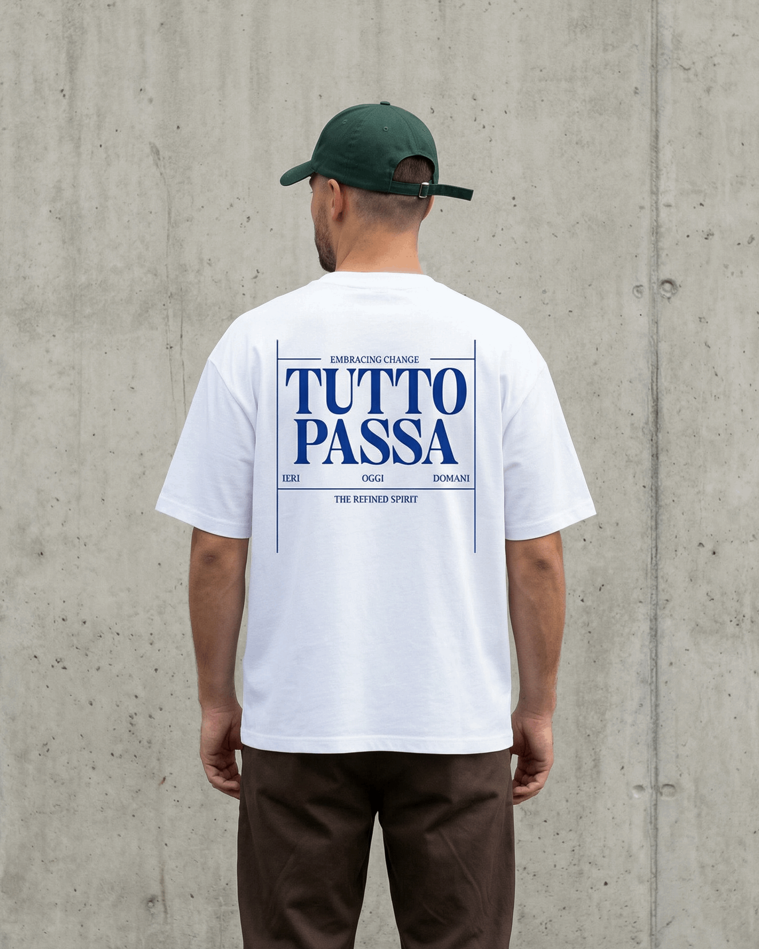 Person wearing a white t-shirt with 'TUTTO PASSA' text, standing against a concrete wall.