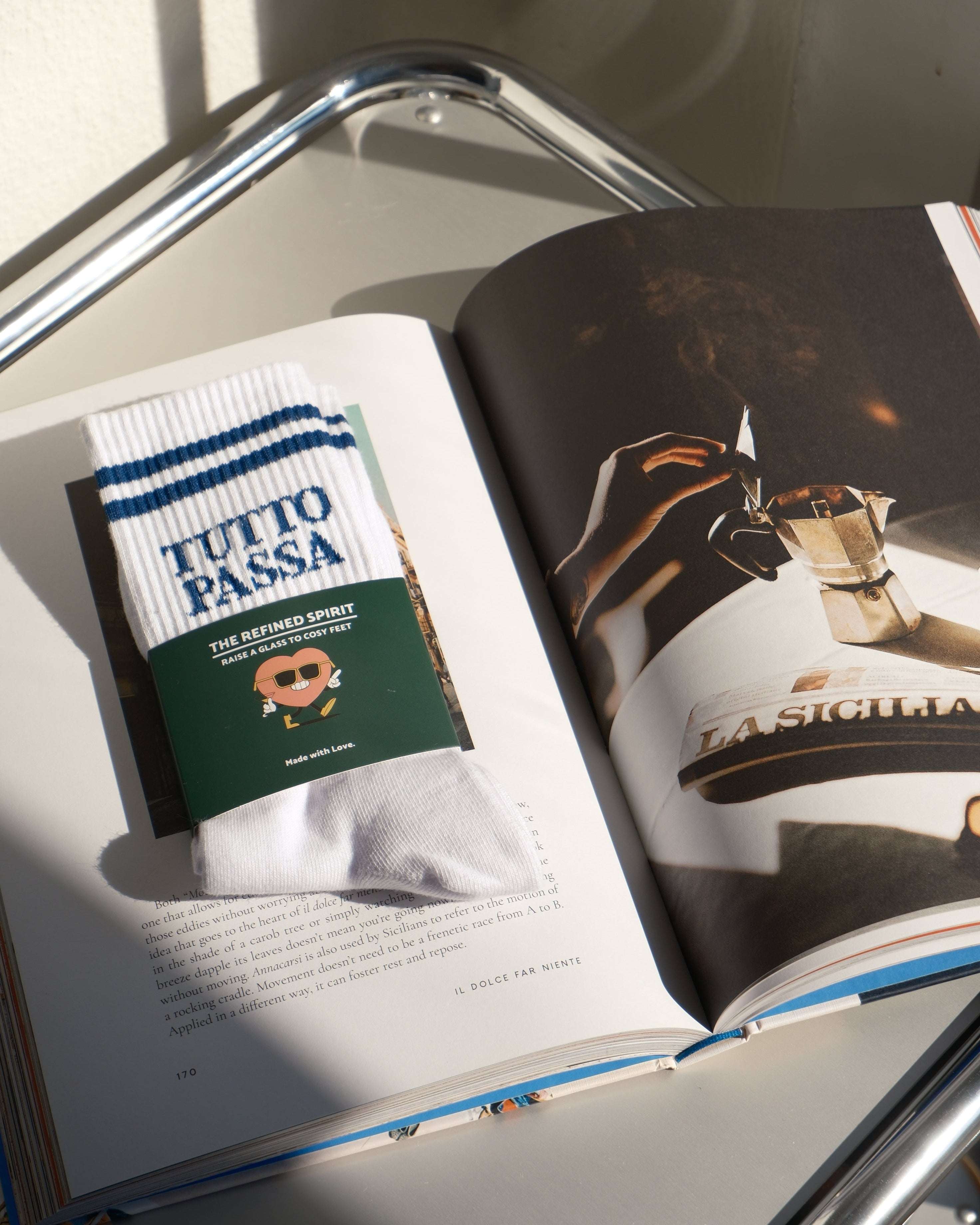 Open book with a Tutto Passa product on a reflective surface